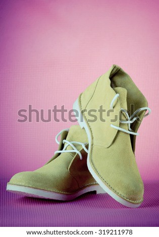 Green male shoes on pink background, filtered image