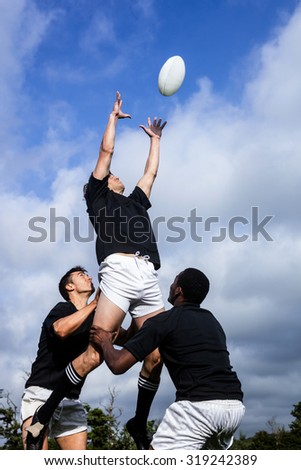 Rugby players jumping for line out at the park Royalty-Free Stock Photo #319242389