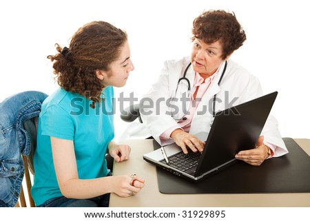 Female doctor has a serious discussion with her teen patient as they go over medical records on the computer.