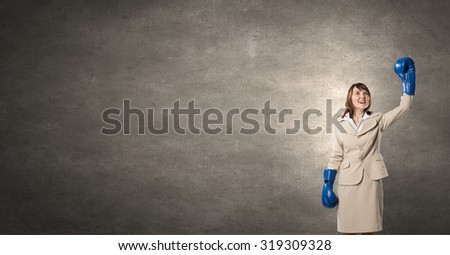 Young businesswoman in blue boxing gloves competition ready