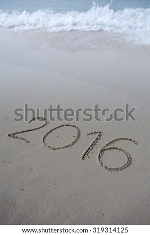 Numbers 2016 on beach - concept holiday background