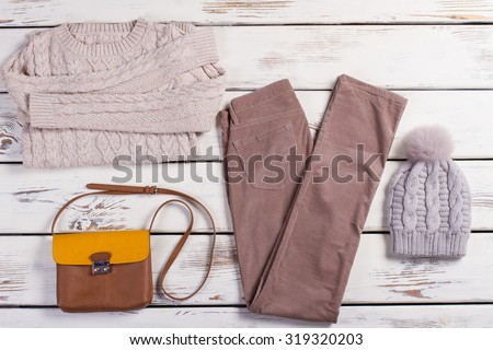 Winter clothes. Set of beautiful light women's clothing on a wooden background.