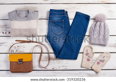 Set of winter clothes. Modern women's clothing on a wooden background.