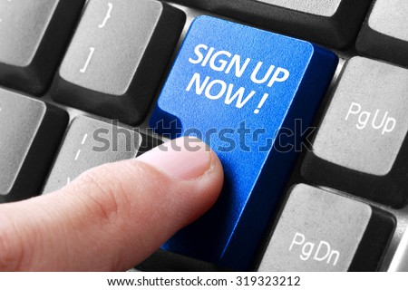Signing up. gesture of finger pressing sign up now button on a computer keyboard
