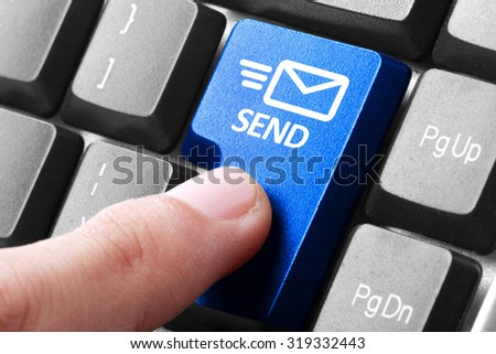 Sending email. gesture of finger pressing send button on a computer keyboard Royalty-Free Stock Photo #319332443