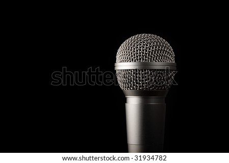 A modern dynamic microphone on a black background.