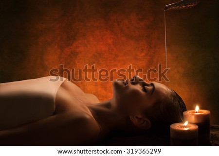 The girl has Shirodhara treatment - indian oil massage. Royalty-Free Stock Photo #319365299