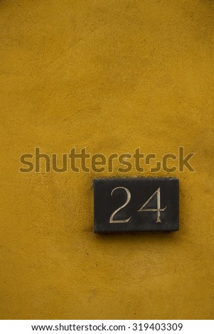 number 24 door sign on mustard yellow wall