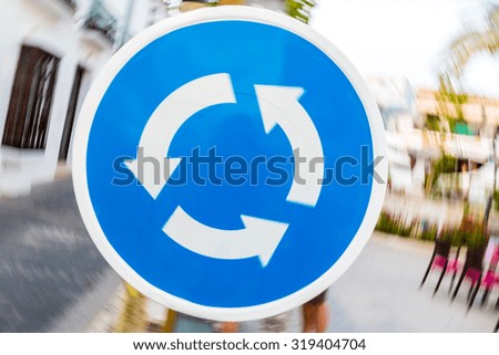 Blue roundabout sign abstract turning blurred motion