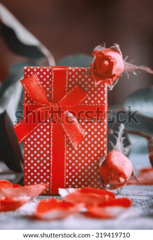  Handmade box with gift  on old pink roses background. Toned image. Retro style.