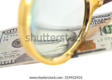 Hundred dollar banknote under magnifying glass isolated