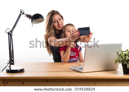 Mother and daughter working in office