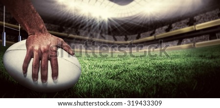 Close-up of sports player holding ball against rugby pitch Royalty-Free Stock Photo #319433309