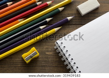 crayons, notebook , eraser and pencil sharpener on the table