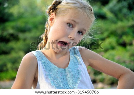 A cute little girl making funny face outdoor