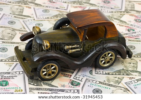 Toy retro car on money background, business concept
