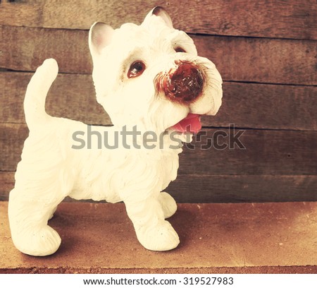 ceramic welcome dog on wooden background still life vintage style with soft motion blur