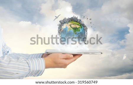 Businessman hands holding tablet pc with Earth planet on it. Elements of this image are furnished by NASA