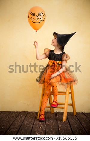 Funny child dressed witch costume. Halloween holidays concept
