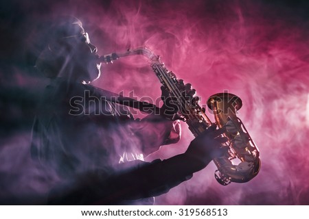 African jazz musician playing the saxophone. Red Color Royalty-Free Stock Photo #319568513