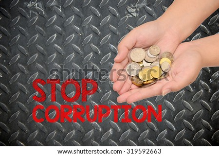hand with coin and stop corruption isolated on steel background