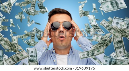 business, finance, luck, fortune and people concept - face of scared or surprised middle aged latin man in sunglasses over blue background with heap of falling dollar money
