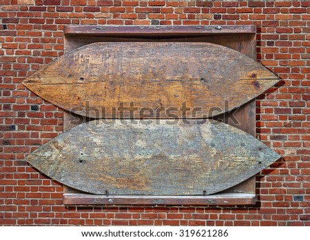 Wooden old sign hanged on brick wall background