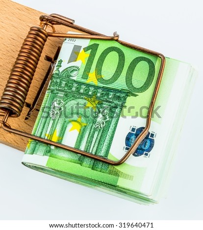many euro banknotes in a mousetrap. symbolic photo for debt and debt on loans.