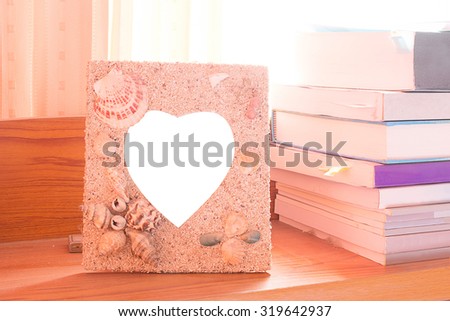 Photo Frame design heart symbol made by sand and shells, On the head bed.