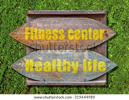 Fitness Center and Healthy Life Wooden old sign hanged on ivy hedge creeper background