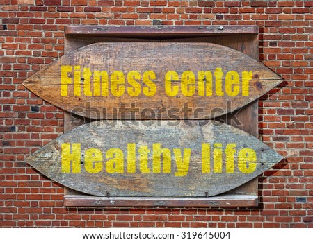 Fitness Center and Healthy Life Wooden old sign hanged on brick wall background