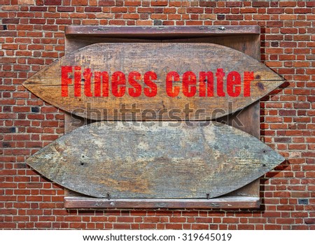 Fitness Center Wooden old sign hanged on brick wall background