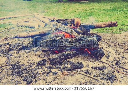 Rustic bonfire outdoors, vintage photo.
