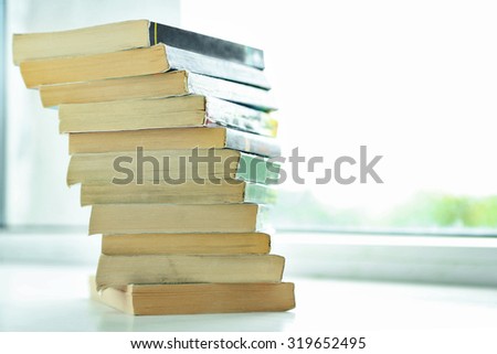 Books on white windowsill, close up