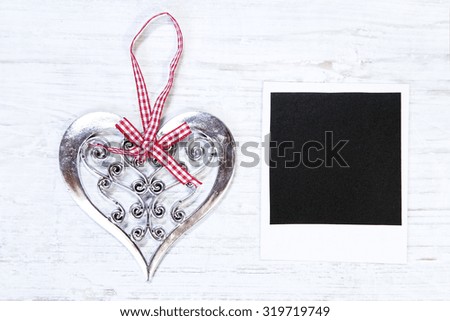 Christmas heart and the blank image on a white wooden background