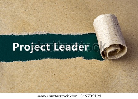 Torn brown paper on green surface with "Project Leader" words.