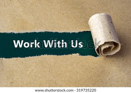 Torn brown paper on green surface with "Work With Us" words.