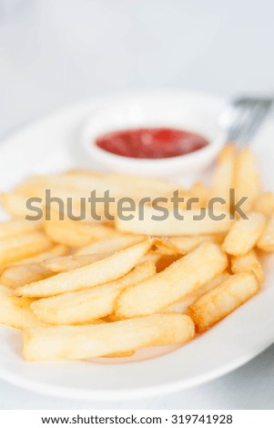 French fries on a white plate, selective focus.
