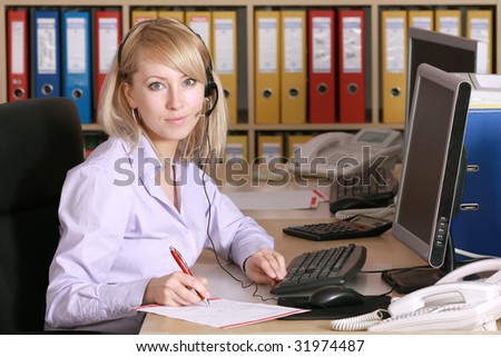 Business woman working in office, looking at camera and smiling