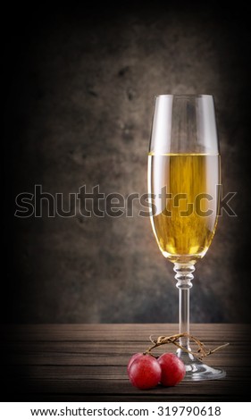 Narrow glass of white wine on wooden table