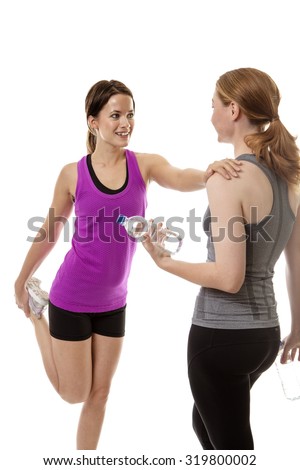 two fitness woman helping each other to stretch before a workout