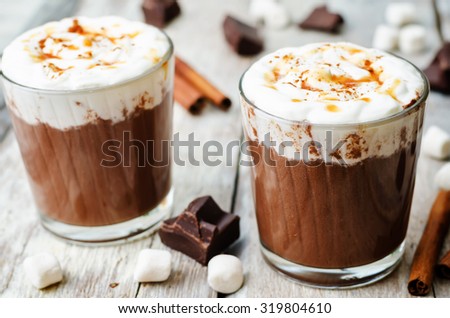 hot dark chocolate with whipped cream, cinnamon and salted caramel. the toning. selective focus