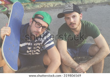 Two young urban skater having fun outdoors.