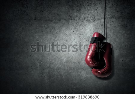 Boxing gloves hanging nailed to wall as concept of retirement Royalty-Free Stock Photo #319838690