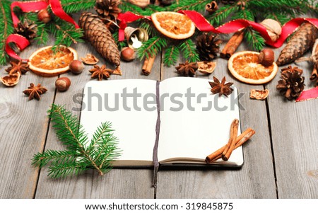 Still life, food and drink, seasonal and holidays concept. Christmas decoration with fir tree, oranges, cones, spices and notepad on a wooden table. Selective focus, copy space background, top view