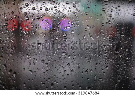 Drops Of Rain On Blue Glass Background. Street Bokeh Lights Out Of Focus. Autumn Abstract Backdrop 