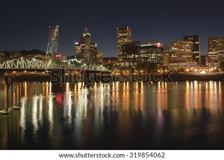 Portland Oregon skyline buildings and bridge at night.