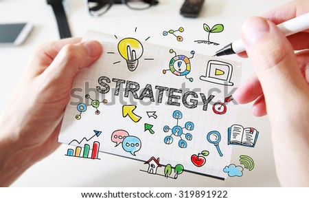 Mans hand drawing Strategy concept on white notebook