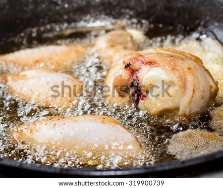Close up of chicken frying in a pan.