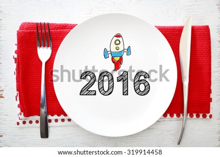 2016 concept on white plate with fork and knife on red napkins